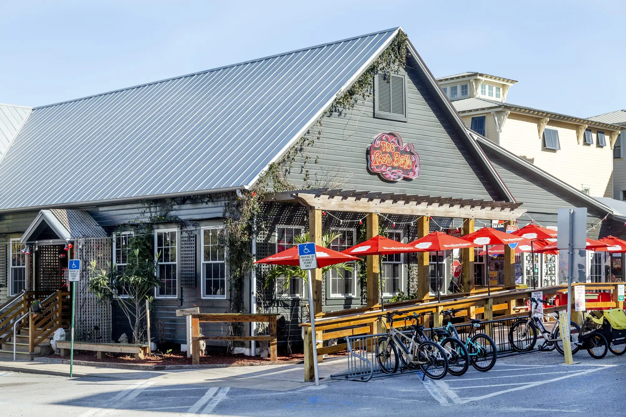 The Red Bar in Grayton Beach, rebuilt timber-framed restaurant with standing seam metal roof and red umbrellas.