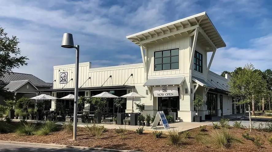 Completed retail building at WaterColor Crossings in WaterColor, Florida, with covered patio seating along the street.